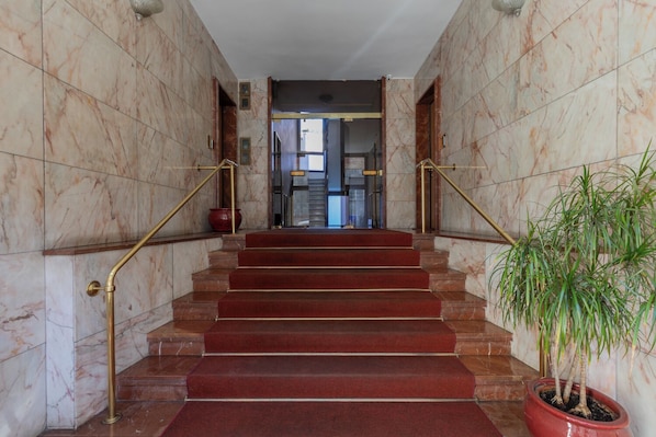 A marble staircase with red carpeted steps, flanked by marble walls and gold handrails. - Ormea Cobalto Apartment by Wonderful Italy (Turin)