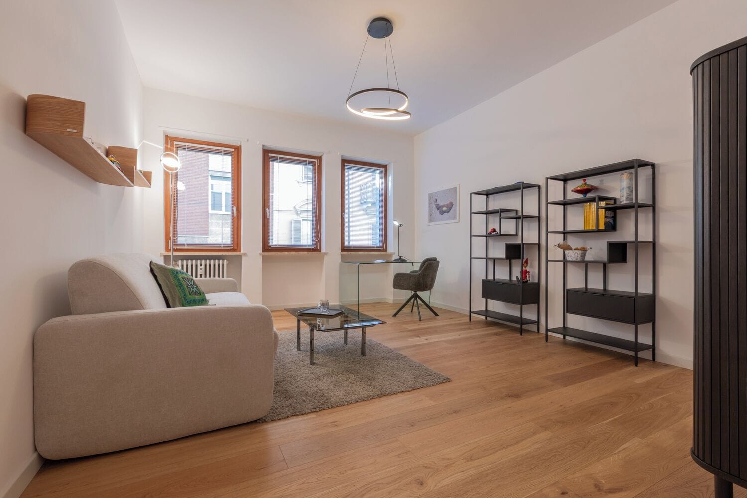 A modern living room with a sofa, a coffee table, and a bookshelf.