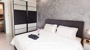 Een moderne slaapkamer met een groot bed, een kledingkast en een nachtkastje.