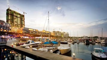 Een jachthaven met aangemeerde boten, een gebouw in aanbouw en een rustige waterkant.