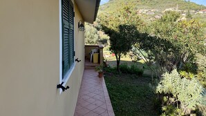 Un balcon donnant sur une colline et un village situé au loin.