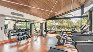 Een sportschool met loopbanden, gewichten en fitnessapparatuur.