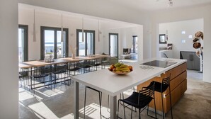 Una cocina moderna con una isla central, ventanas amplias y vista al mar.