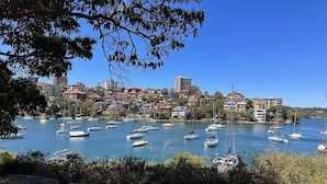 A marina with multiple sailboats docked, surrounded by residential buildings and greenery. - Mosman Bay - ROSE2 - Rose Crescent - Art Deco Mosman Bay home (Mosman)