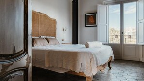 A bedroom with a bed, a window, and a view of the outside. - La Pagliera  (Agrigento)