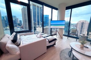 Une chambre d’hôtel moderne dotée d’un grand lit, d’une télévision et d’un balcon offrant une vue sur la ville.