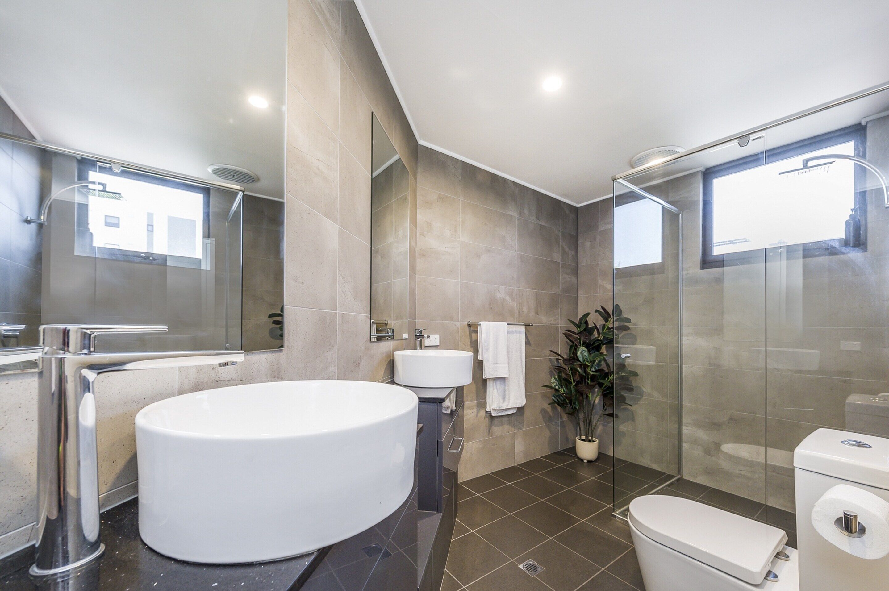 A modern bathroom with a large bathtub, a separate shower area, and a toilet.