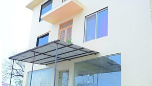 A multi-story building with a flat roof, large windows, and a covered outdoor area. - Hotel shri ram krishna mahal (Ayodhya)