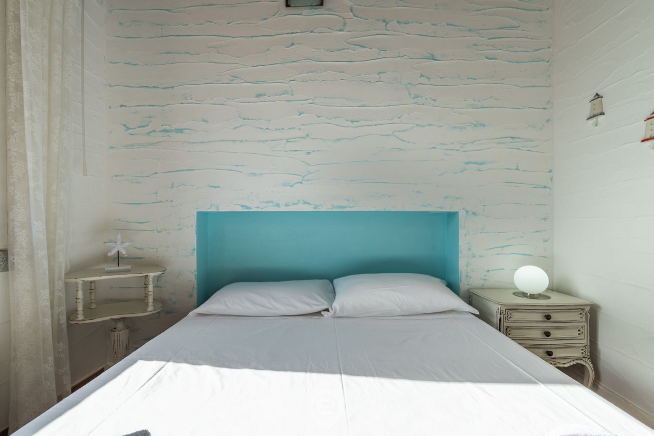 Un dormitorio con cama, mesita de noche y cómoda.