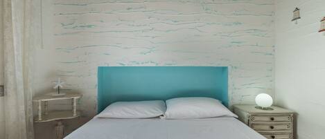 Un dormitorio con cama, mesita de noche y cómoda.
