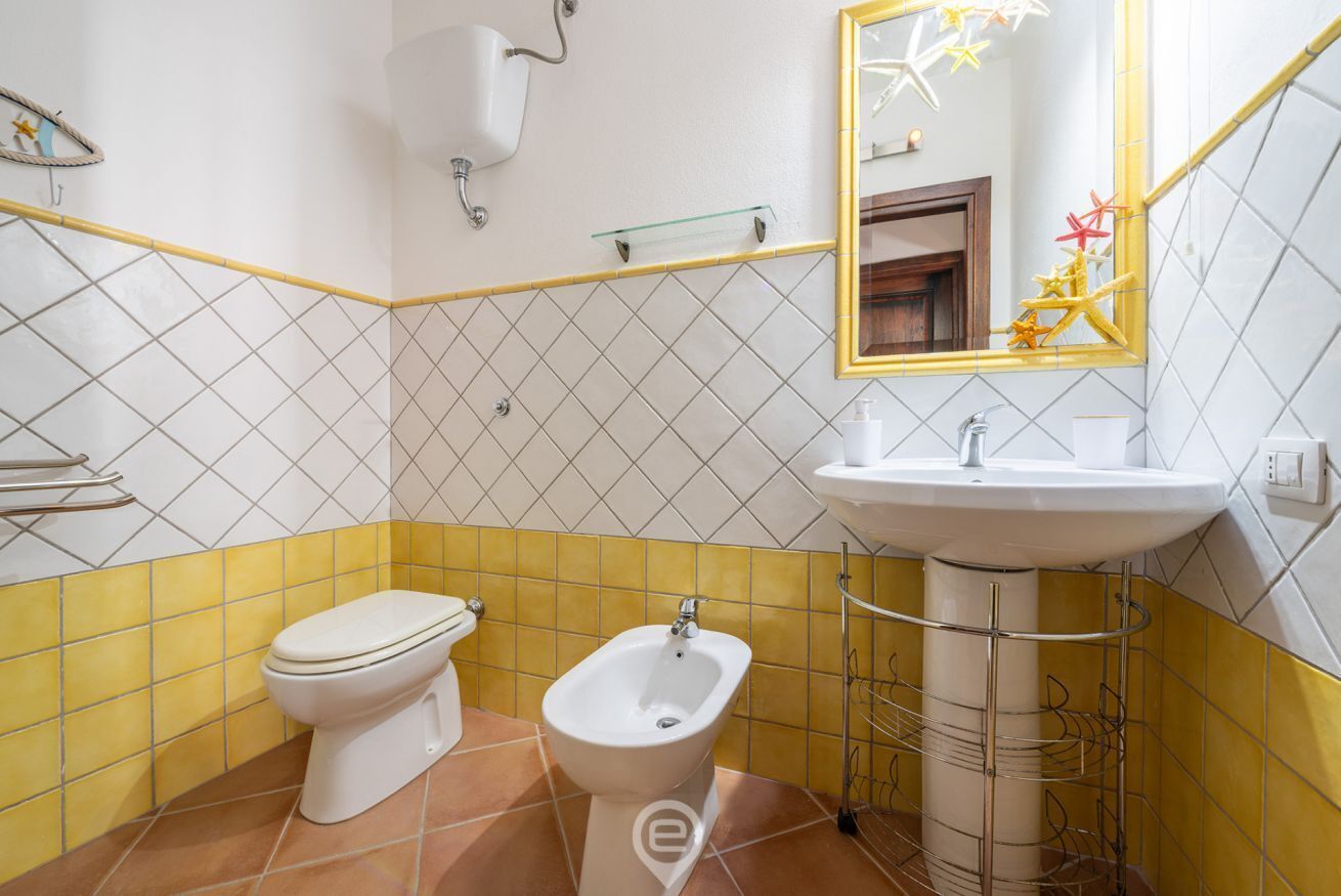 Een badkamer met toilet, bidet en wastafel.