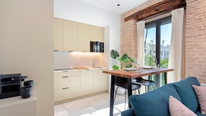 Een moderne keuken met een inbouwoven en een eethoek met een tafel en stoelen.
