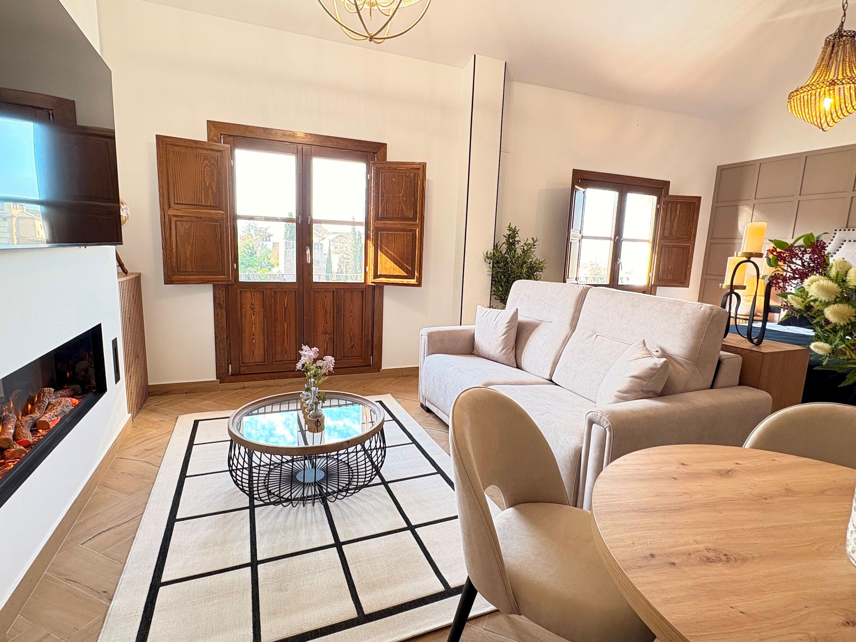 A modern living room with a fireplace, a sofa, a round coffee table, and a dining table.