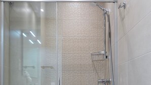 A modern bathroom with a glass-enclosed shower, a white toilet, and a wooden vanity. - Cozy Central 2BD Apt in M Laga Trinidad Grund A (Málaga)