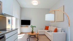 A modern living room with a sofa, a coffee table, and a TV. - Cozy Central 2BD Apt in M Laga Trinidad Grund A (Málaga)