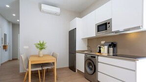 A modern kitchen with a built-in washing machine, a microwave, and a refrigerator. - Cozy Central 2BD Apt in M Laga Trinidad Grund A (Málaga)