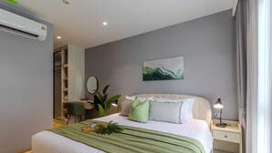 Une chambre bien rangée, avec un lit, une table de chevet et un bureau avec une chaise.