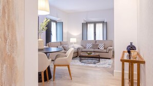 Een moderne woonkamer met een bank, salontafel en een eethoek.