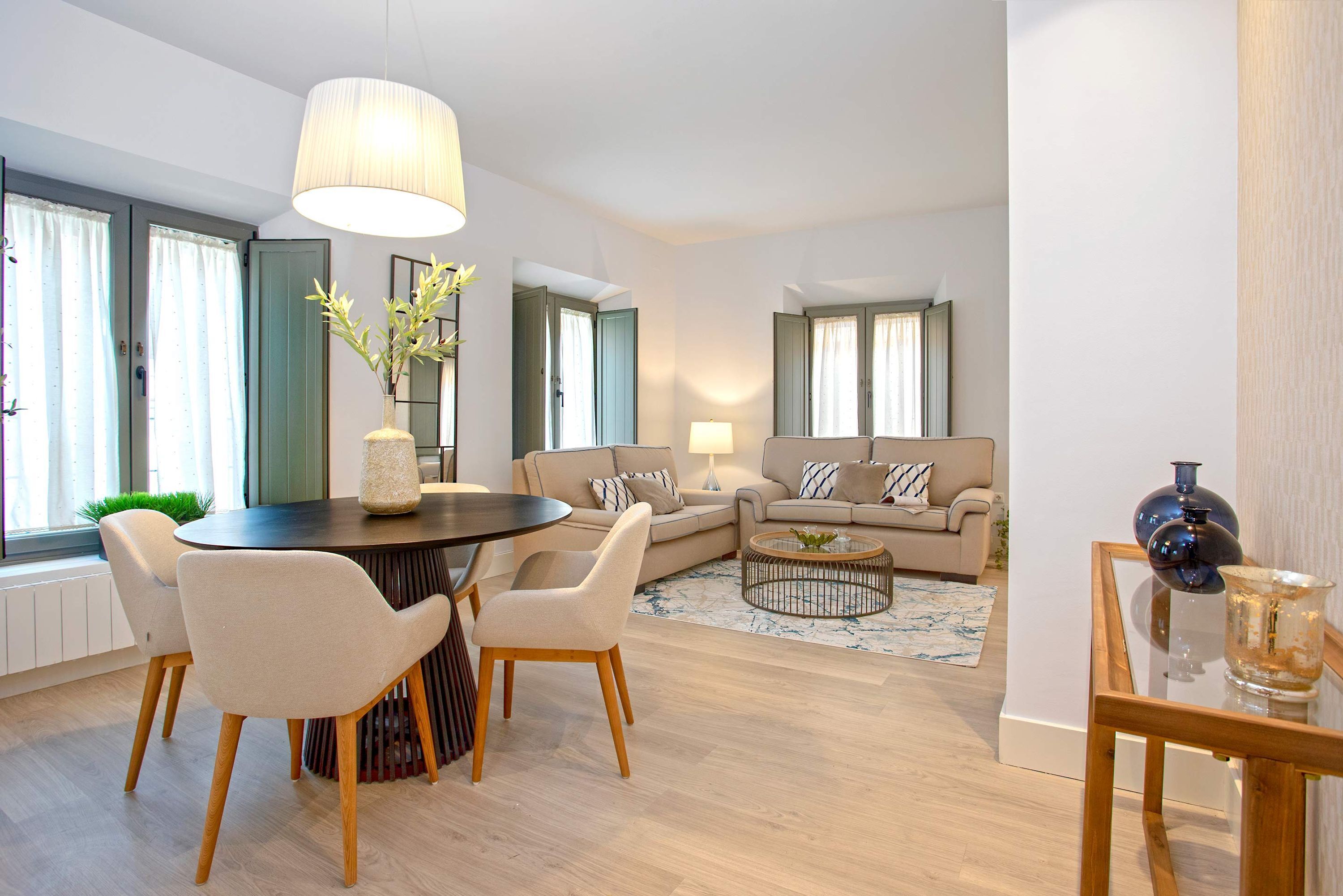 Un salon moderne avec une table à manger ronde, deux canapés et une table basse.