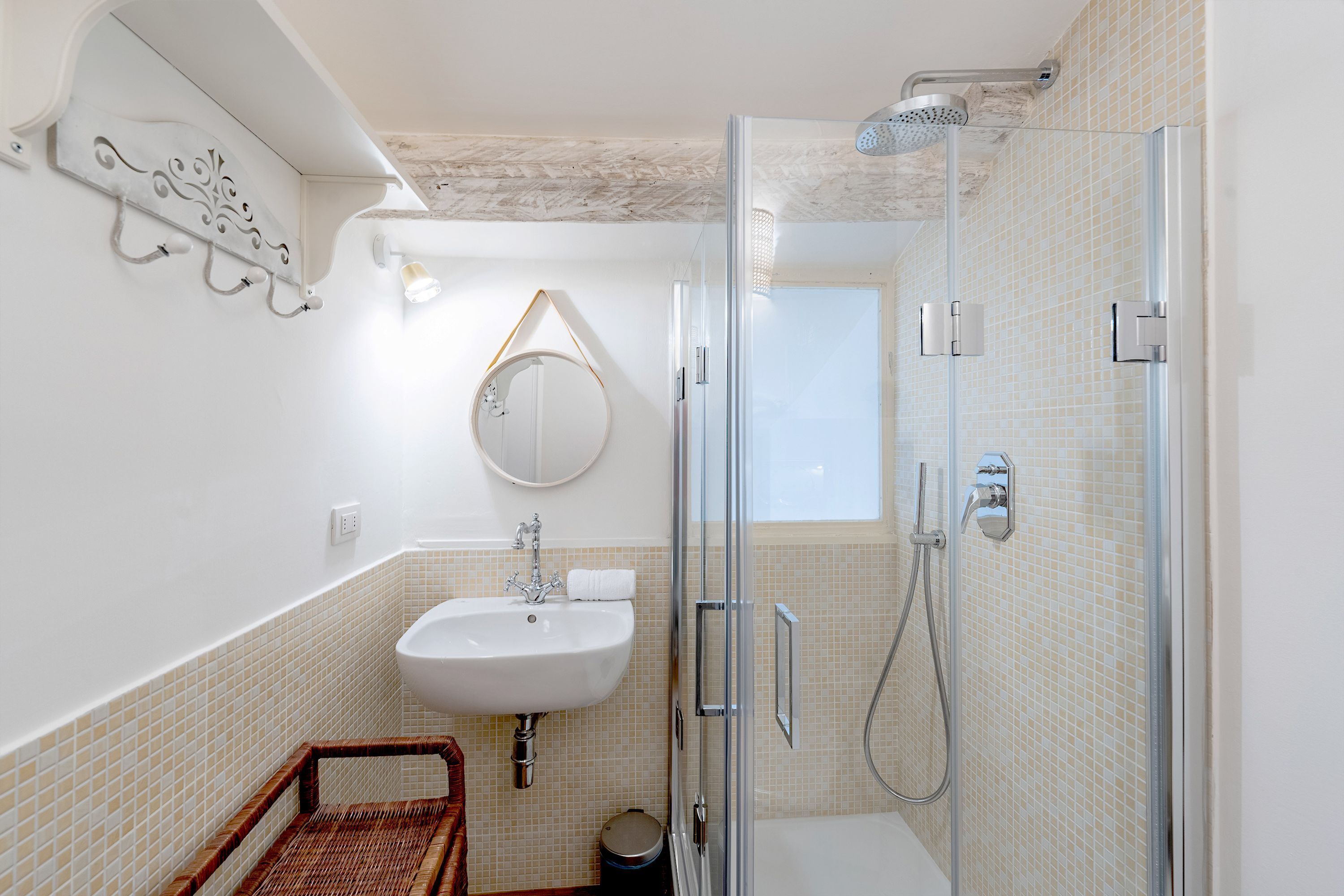 Un baño con cabina de ducha de vidrio, un lavabo y un espejo.