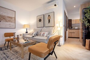 A modern living room with a sofa, armchairs, a coffee table, and a dining area. - Exclusive Apartment in Granada Horno Marina 9 (Granada)