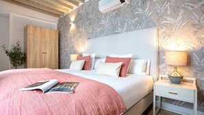 Una camera da letto con un letto, comodini e condizionatore.