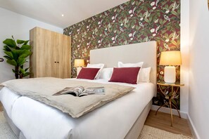 A neatly made bed with a magazine, two pillows, and a bedside table with a lamp. - Exclusive Apartment in Granada Horno Marina 11 (Granada)