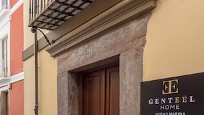 A building entrance with a wooden door, a balcony with a metal railing, and a sign that reads "GENTEEL HOME HORNO MARINA". - Exclusive Apartment in Granada Horno Marina 11 (Granada)