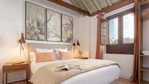 A bedroom with a large bed, two bedside tables, a nightstand, and a window with curtains. - Luxury Apartment in Granada Horno Marina 6 (Granada)