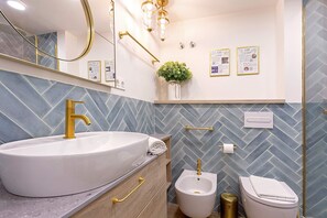 A bathroom with a large white sink, gold fixtures, a bidet, and a toilet. - Luxury Loft in Granada Center La Paz II (Granada)