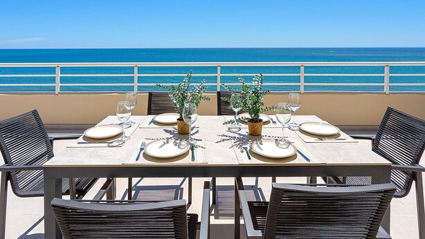 A table set for two with a view of the ocean. - Exclusive Penthouse in Fuengirola Beach Corales (Fuengirola)