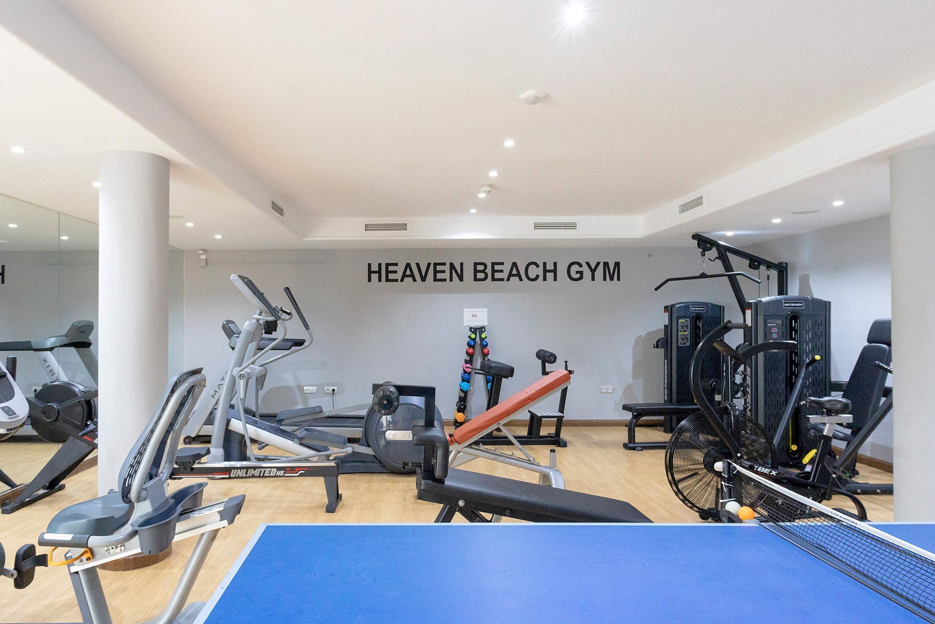 A gym with various exercise equipment, including treadmills, stationary bikes, and weight machines.
