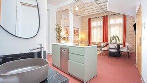Une cuisine moderne dotée d’un lave-vaisselle encastré, d’un grand îlot central et d’un coin repas avec une table et des chaises.