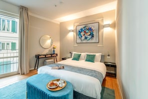 A modern hotel room with a large bed, a bedside table, a desk, and a window with curtains. - Central 3BD Apartment Near Teatro Verdi (Florence)