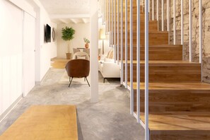Un interior moderno con una escalera, un sofá y una mesa de comedor.