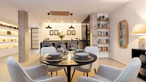 A modern dining area with a round table set for four, surrounded by light grey upholstered chairs. - Lovely Apartment in Seville Pureza (Seville)