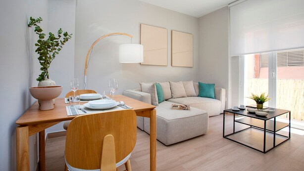 Una sala de estar moderna con una mesa de comedor, un sofá y una mesa de centro.