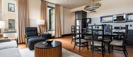 Una habitación de hotel moderna con zona de estar, comedor y cocina.