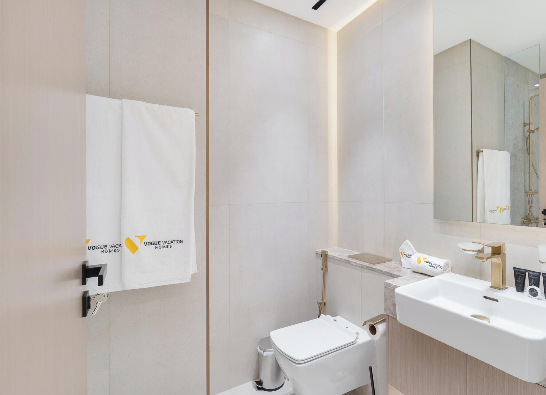 A modern bathroom with a toilet, sink, and mirror.