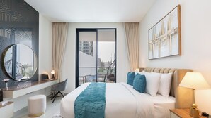 Ein modernes Hotelzimmer mit einem großen Bett, einem Schreibtisch, einem Sessel, einem runden Spiegel und Blick auf die Stadt durch das Fenster.