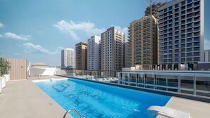 Ein Dachpool mit freiem Blick auf hohe Gebäude im Hintergrund.