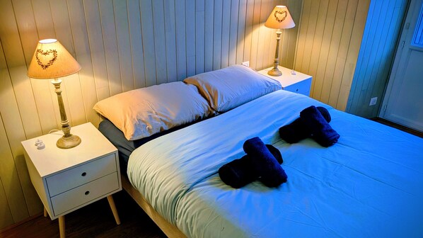 A neatly made bed with two pillows, two bedside lamps with heart designs, and a small drawer unit. - Apartment '6 Pers All ée D'Étigny' with Mountain View, Balcony and Wi-Fi (Bagnères-de-Luchon)