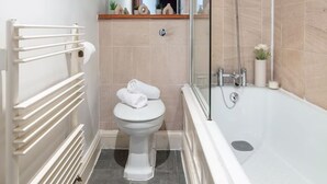 Un baño moderno con ducha envuelta en vidrio, inodoro blanco y bañera.