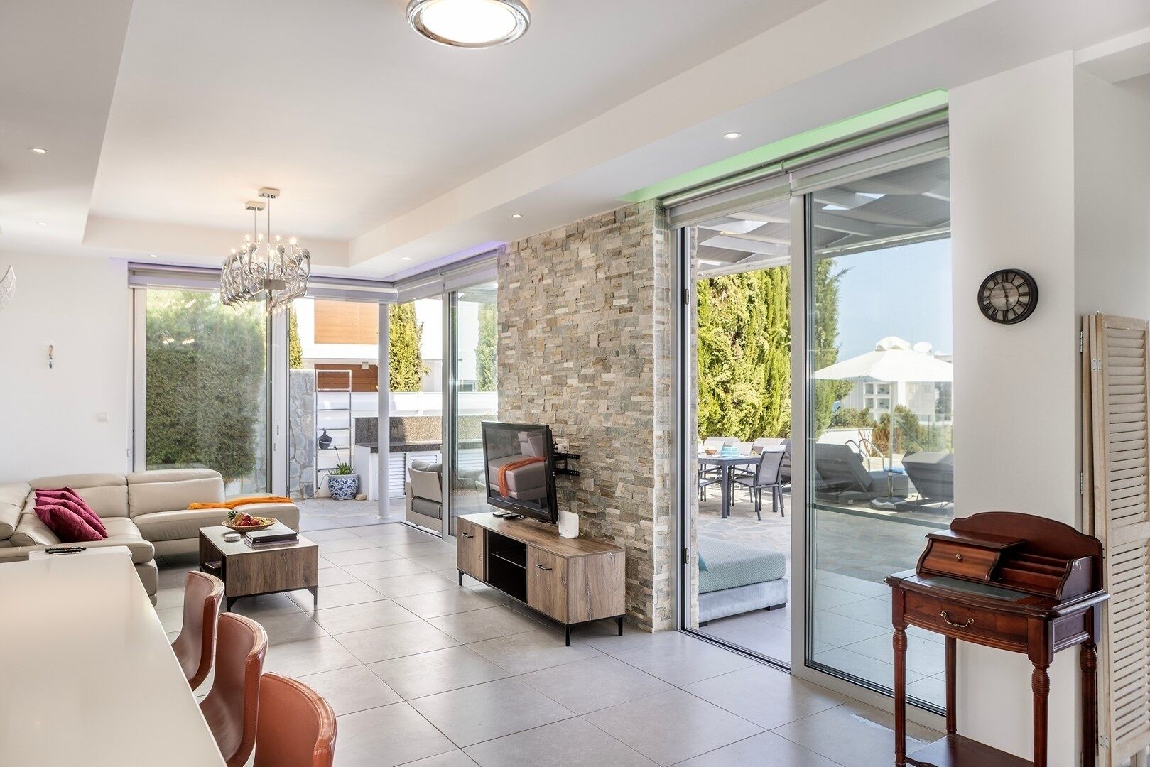 A modern living room with a TV, sofa, and dining area.