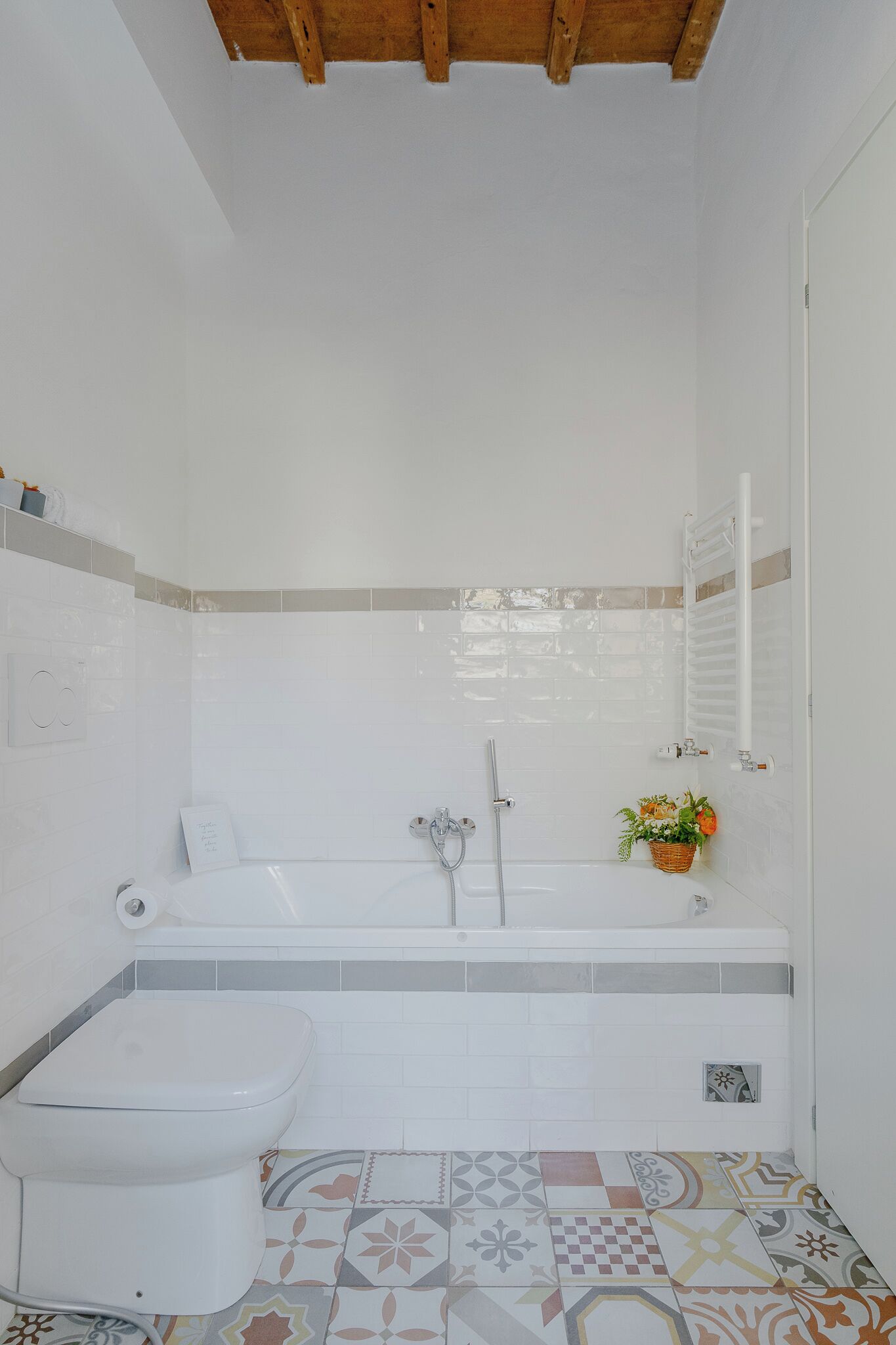 Un bagno con vasca, WC e pavimento piastrellato.