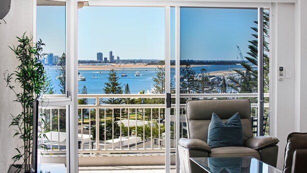 Ein Balkon mit Blick auf einen Yachthafen und Stadtpanorama.
