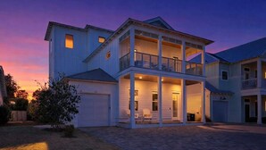 A two-story house with a covered front porch, a garage, and a small front yard. - Beach Please by Stay on 30a (Inlet Beach)