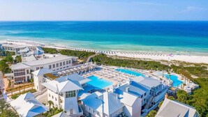 Een resort met een zwembad, strand en uitzicht op de oceaan.