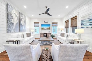 A spacious living room with white furniture, a ceiling fan, and artwork on the walls. - Best Kept Seacrest by Stay on 30a (Seacrest Beach)