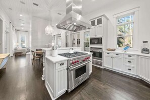 A spacious kitchen with white cabinetry, stainless steel appliances, and a large island. - SSYS by the Sea by Stay on 30a (Watercolor)